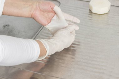 Eller lateks eldivenleri çıkarsın. Kişisel koruma. Metal lavabodaki sabun.