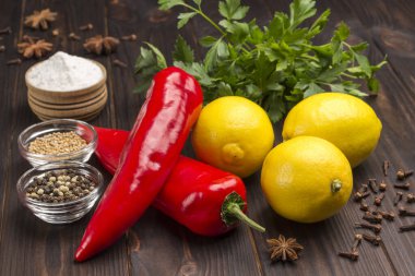 Üç limon ve iki kırmızı biber, maydanoz, tuz ve baharat. Bağışıklığı güçlendirmenin doğal kaynağı. Üst Manzara. Koyu Ahşap arka plan