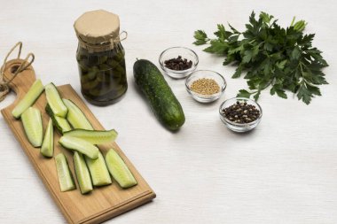 Konserve salatalık, doğranmış salatalık, yeşil maydanoz ve baharat. Ev yapımı Fermantasyon Ürünleri. Sağlıklı kış besinleri. Beyaz arka plan. Üst görünüm