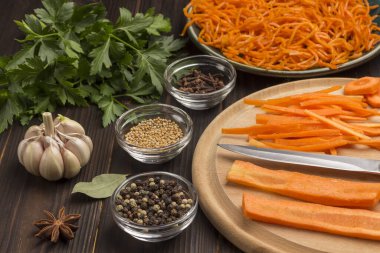 Kesme tahtasında taze doğranmış havuç. Tabakta mayalanmış havuç. Baharat, sarımsak ve maydanoz. Bağışıklık sistemini güçlendirmek için doğal bir ilaç. Kapatın. Koyu tahta arkaplan