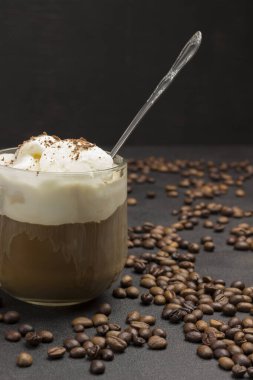 Bardak kahve, soğuk kahve ve dondurma karışımı. Siyah arkaplanda kahve çekirdekleri