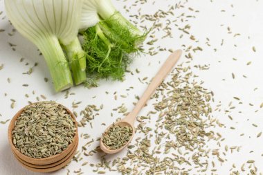 Rezene tohumları kaşıkta, kutuda, masada. Beyaz arka plan. Üst Manzara. Kapat.