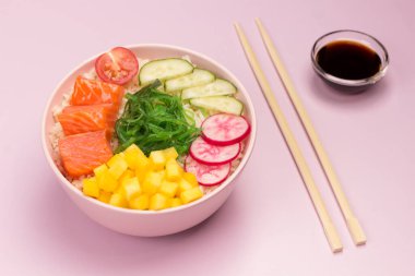 Tavada nane ve biberiye ile doğranmış nehir balığı. Masada domates, limon ve cam şişe yağ var. Siyah arka plan. Üst görünüm