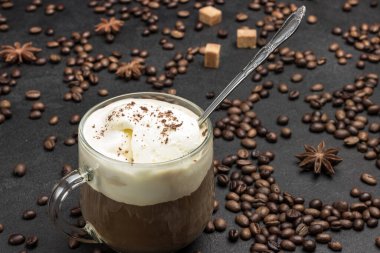 Bardak kahve, soğuk kahve ve dondurma karışımı. Siyah arka planda kahve çekirdekleri. Üst Manzara. Kapat.