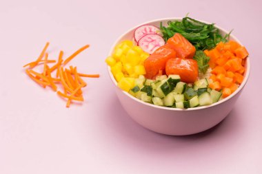 Çiğ balık ve sebzelerle karıştırın. Hawai yemeği. Üst Manzara, kapat. Pembe arka plan. Sağlıklı, temiz yeme konsepti. Boşluğu kopyala