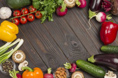 Koyu ahşap arka planda çok renkli sebze, roka ve yeşil soğan seti. Vegan gıda konsepti. Boşluğu kopyala