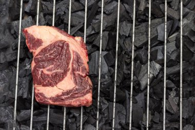 Çiğ et. Izgarada mermer biftek. Doğal protein kaynağı. Organik yiyecekler. Düz yatıyordu