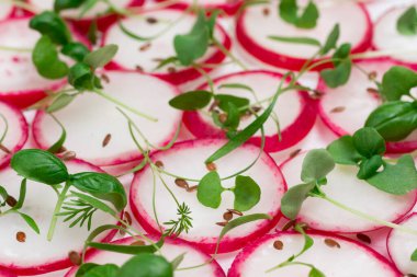 Dilimlenmiş turp ve keten tohumu ve taze mikroyeşil lahanası, sağlıklı beslenme. Düz yatıyordu. Beyaz arkaplan