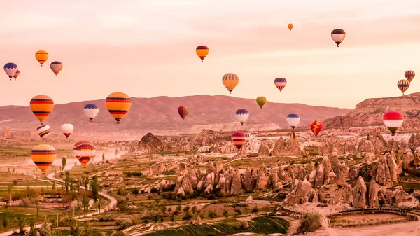 Kolorowe gorące powietrze balony latające nad opoka pejzaż w Cappadocia — Zdjęcie stockowe