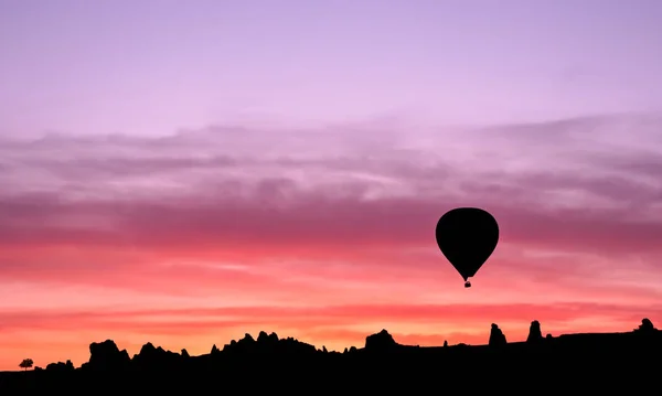 Silueta de globo de aire caliente en las montañas al amanecer, Goreme —  Fotos de Stock