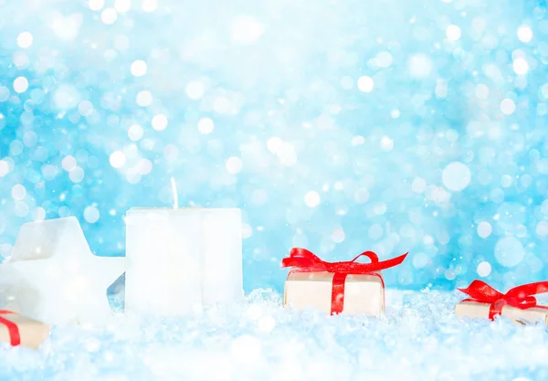 Χριστουγεννιάτικο φόντο με κουτιά δώρων και κεριά στο χιόνι — Φωτογραφία Αρχείου