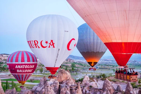 GOREME, CAPPADOCIA, TURQUÍA - 19 DE ABRIL DE 2018: Colorido globo aerostático volando sobre el paisaje rocoso en Capadocia, Turquía —  Fotos de Stock