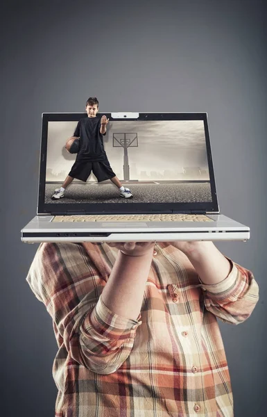Hålla en laptop som visar en basketmatch — Stockfoto
