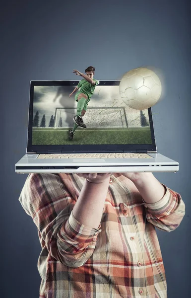 Segurando um laptop que exibe um jogo de futebol na tela — Fotografia de Stock