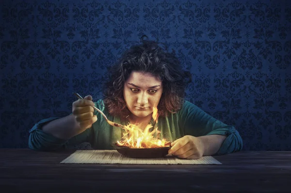 Mladá žena jíst pálivá jídla — Stock fotografie