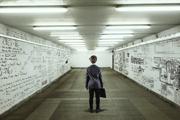 Businessman go through a tunnel with walls full of mathematical formulas and sketches
