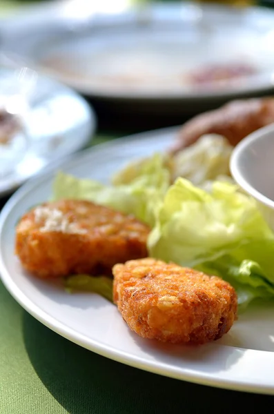 Pepitas de frango e salada vegetal em uma chapa branca — Fotografia de Stock