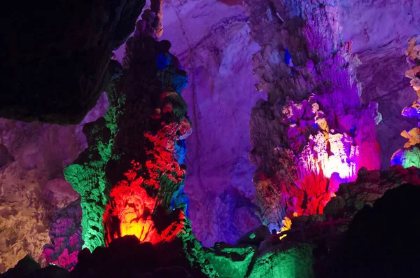 Gyönyörű megvilágított tarka cseppkövek a karszt Reed Flute barlang. Guilin Guangxi China — Stock Fotó