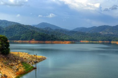 Adam toplayan Sungai Selangor Baraj Gölü öğlen sırasında yaptı.