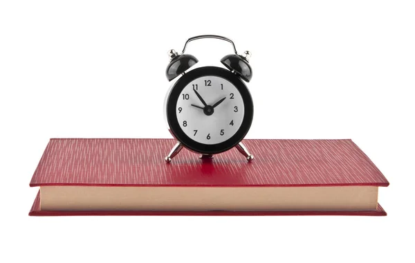 Black alarm clock on red book isolated on white background — Stock Photo, Image