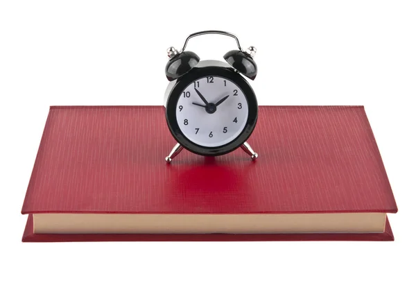 Black alarm clock on red book isolated on white background — Stock Photo, Image