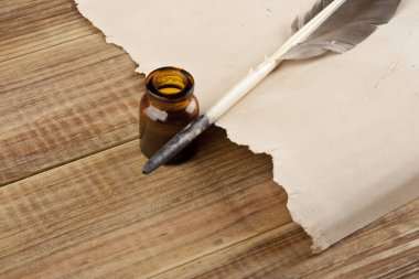 Eski kağıt ve mürekkep ahşap bir masa üzerinde bir kalemle