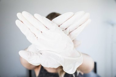 Koruyucu beyaz eldivenler giyen çapraz eller