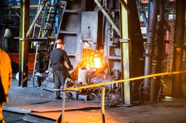 alt tutun çekiç altında kırmızı-sıcak demir çubuk