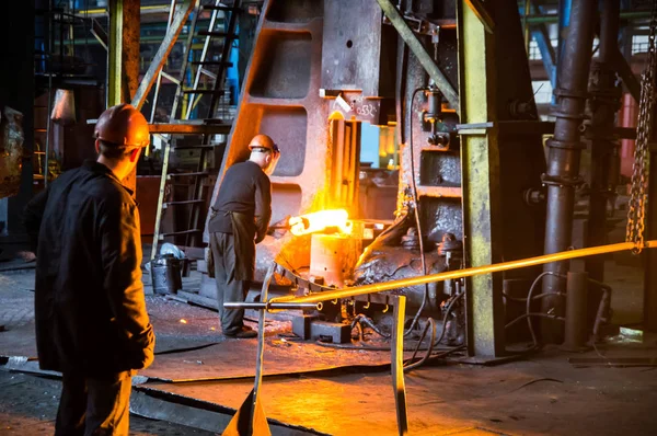 Arbeiter halten das Werkstück unter den Hammer — Stockfoto