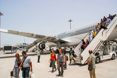 Qatar. May 2009. Passengers disembark from the aircraft Qatar Ai clipart