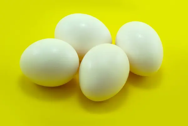 Banyak telur putih horizontal di latar belakang kuning — Stok Foto
