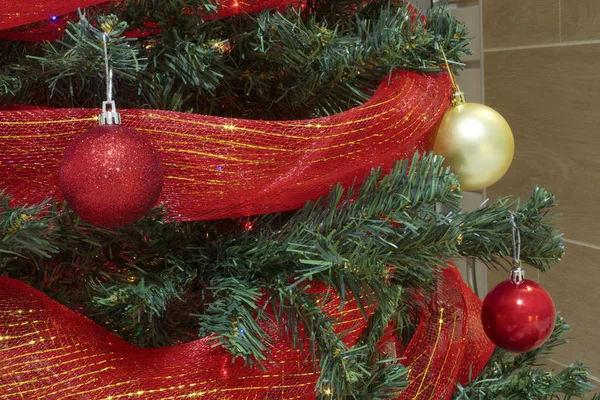 Červené a zlaté vánoční ozdoby s mašlí na stromě — Stock fotografie