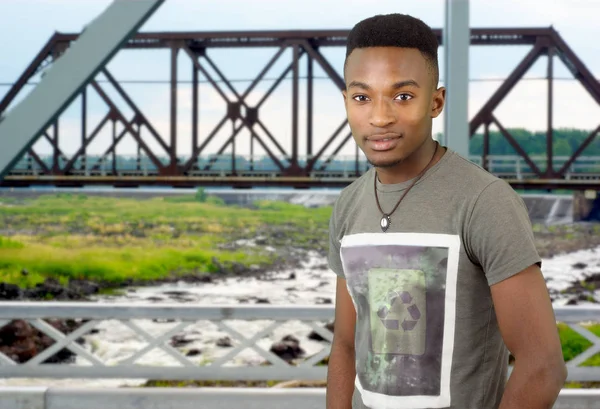 Hombre joven en estructura de puente de metal, vigas de río y ferrocarril — Foto de Stock