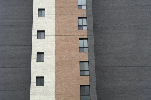 Ladrillos pared, ventanas patrón vertical, edificio de oficinas gris — Foto de Stock