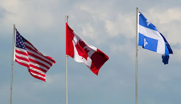 Bandeiras do Canadá, EUA e Quebec acenando no dia nublado do vento — Fotografia de Stock