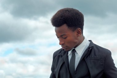 genç işadamı gelecekteki dramatik gökyüzü takım elbise ve kravat hakkında düşünme