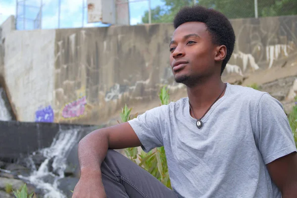 Fiatal ember ül a folyó töprengő gondolkodás törekvéseit — Stock Fotó