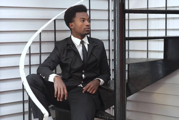 Ung man svart kostym och slips sitter trappor affärsman professional — Stockfoto