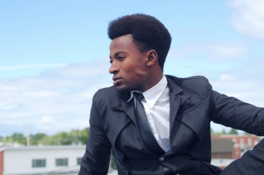 genç işadamı oturma bina çatı takım elbise ve kravat