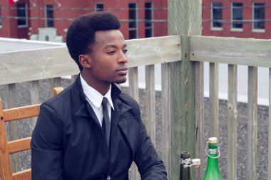 içme ve yalnız Restoran Teras masada bekleyen genç Afrika adam sıkılmış