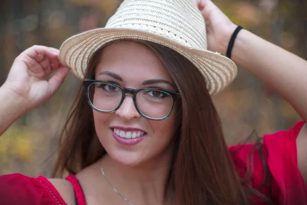 Mujer joven pelo marrón gafas vestido rojo sonriendo retrato exterior —  Fotos de Stock