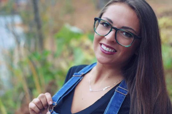 Unga kvinnor porträtt i naturen glasögon overaller pretty girl — Stockfoto
