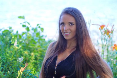 Arka plan ve çiçekler dışında gülümseyen bir kadın.