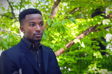 Doğadaki genç adam başarılı temsilci mutlu müşteri açık hava yeşil ağaçları