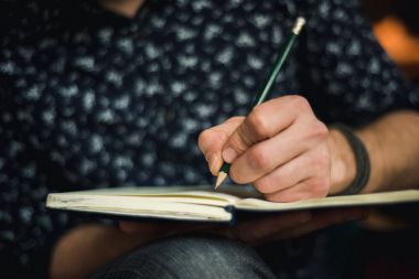 Adam günlükte bir kalemle yazma