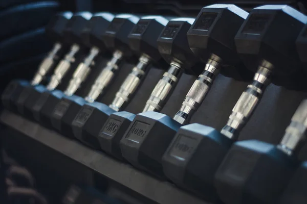 Üst üste farklı ağırlıklı dambıl, yakın çekim.