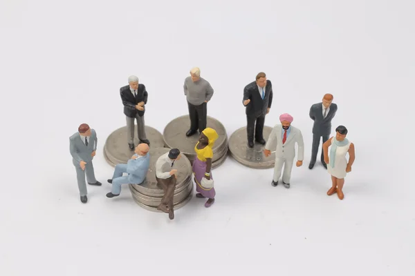 Grupo Personas en miniatura en monedas —  Fotos de Stock