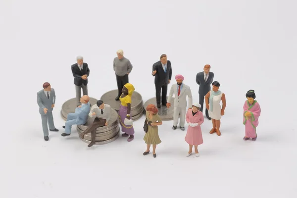 Grupo Pessoas em miniatura em moedas — Fotografia de Stock