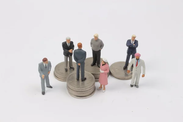 Grupo Personas en miniatura en monedas —  Fotos de Stock