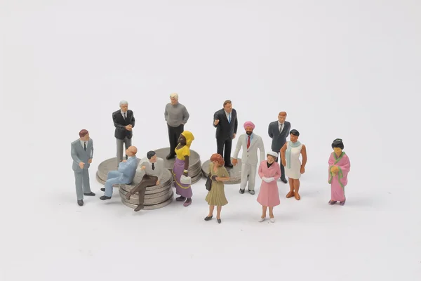 Grupo Personas en miniatura en monedas — Foto de Stock